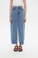 Pantalón jean slouchy de tiro alto, color natural, con detalle de bordadoado en el borde inferior.