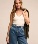 Musculosa de tejido de punto acanalado color blanco, con escote en V y tirantes anchos.