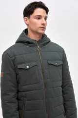 Campera de gabardina capitoneada con interior forrado en nylon. Presenta capucha fija, bolsillos frontales en el pecho con solapa y bolsillos laterales con cierre. Cuenta con cierre frontal central.