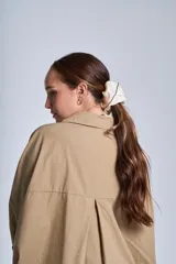 Camisa oversize color beige de manga larga con bolsillos frontales.