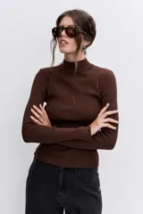 Blusa de punto acanalado en color azul marino, con cuello alto y mangas largas ajustadas.