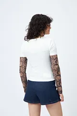 Remera blanca de corte ajustado con cuello redondo y mangas cortas. Presenta una estampa frontal en color marrón con el texto 'Wild hearts can't be broken' y un diseño de caballo dentro de un corazón.