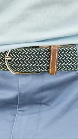 Cinto unisex de diseño trenzado elastizado en color verde y blanco, con detalles en cuero sintético color suela y hebilla metálica plateada.