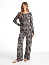 Conjunto de pijama compuesto por una remera de manga larga con puños y un pantalón de corte recto con cintura elástica y lazo de ajuste. Presenta un diseño de rayas horizontales finas en tonos gris y negro.