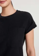 Vestido corto marrón de corte recto y holgado, con mangas cortas con vuelta, cuello redondo y un bolsillo aplicado en el pecho.