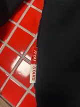 Hoodie negro con capucha y estampa gráfica blanca en la espalda con diseño tipográfico cursivo. Presenta puños y ruedo acanalados.