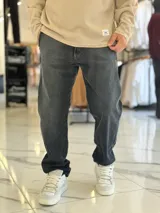 Pantalón de jean gris oscuro, de corte relajado y estilo urbano.