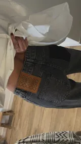 Jean de corte holgado en color gris con efecto lavado, caracterizado por sus lazos ajustables en los tobillos.