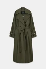 Trench oversize de Zara Woman Collection, color verde militar, con cuello solapa, cierre frontal cruzado con botones y cinturón ajustable del mismo tejido. Presenta mangas largas con trabillas ajustables y bolsillos delanteros.
