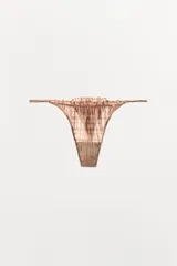 Tanga de tiro medio con diseño de cuadros, confeccionada en tejido semitransparente con detalles de elásticos fruncidos y acabados en volantes a tono.