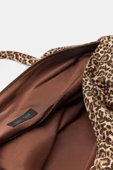 Maxi bolsa de algodón con estampado animal print, diseño rectangular con asas de hombro y bolsillos laterales.