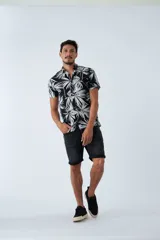 Camisa de manga corta con estampado botánico de hojas en tonos azul y blanco. Presenta cuello clásico, cierre frontal abotonado y corte slim.