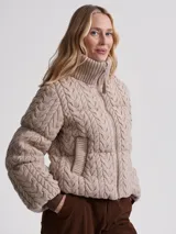 Campera puffer beige con cuello alto acanalado, cierre frontal con cremallera y bolsillos laterales.