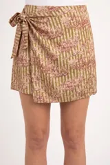 Falda corta tipo pareo con lazo lateral, confeccionada en tela fluida con estampado toile de jouy sobre fondo de rayas verticales.