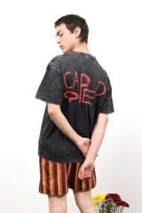 Remera de algodón con efecto lavado, cuello redondo y mangas cortas. Presenta un pequeño logo estampado en el pecho y una estampa de mayor tamaño en la espalda.