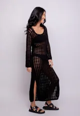 Vestido largo negro de tejido de punto calado, con escote redondo y mangas largas acampanadas.