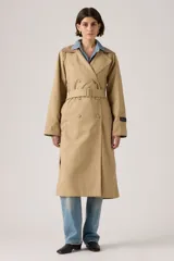 Trench coat largo de corte clásico en color beige, con diseño de doble botonadura, solapas amplias y cuello con detalle de textura. Presenta un estilo atemporal y estructurado.