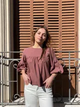 Blusa color chocolate de diseño holgado, con cuello redondo, frunce frontal y mangas abullonadas con puños ajustados.