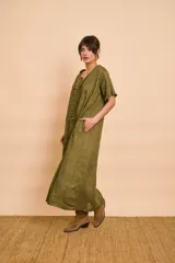 Vestido tipo túnica largo de lino color beige, de manga corta, con detalles de volados en el frente y bolsillos laterales.
