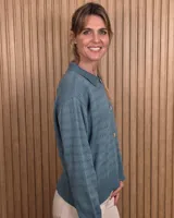 Cardigan de punto color marrón tostado, con cuello camisero, cierre frontal con botones y diseño de rayas sutiles en el tejido. Presenta mangas largas con puños elásticos y corte recto.