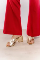 Sandalia color beige con tiras cruzadas y hebilla metálica cuadrada. Taco cuadrado de 6 cm.