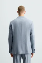 Blazer de corte slim fit confeccionada en tejido con lana, con cuello de solapas de muesca, cierre frontal de un botón, bolsillos laterales con solapa y bolsillo de vivo en el pecho.