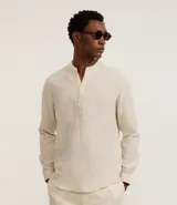 Camisa de manga larga confeccionada en mezcla de lino y algodón, con cuello tipo padre y cierre frontal parcial con botones. Presenta un corte amplio y cómodo, ideal para un estilo casual y fresco.