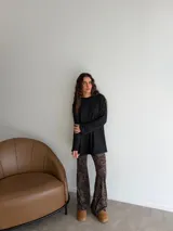 Conjunto compuesto por un buzo de punto acanalado en color beige con cuello redondo y mangas largas holgadas, y un pantalón tipo oxford de tiro alto con estampado animal print de leopardo.