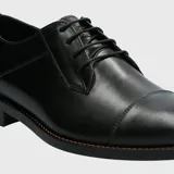 Zapato de vestir formal Hush Puppies, confeccionado en cuero negro con diseño tradicional de puntera recta y cierre mediante cordones. Cuenta con plantilla de cuero transpirable y suela de goma.