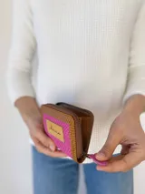 Billetera pequeña con cierre metálico, cuerpo principal en tejido texturizado color fucsia y detalles en cuero marrón con textura de reptil. Posee un parche de cuero claro con la palabra "chowie" escrita a mano.