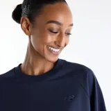 Remera New Balance de corte amplio y suelto, color azul marino, con cuello redondo, mangas raglán cortas, aberturas laterales y pequeño logotipo bordado en el pecho al tono.