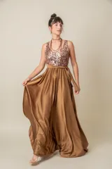Vestido largo rojo con cuerpo de lentejuelas y falda de satén con caída fluida. Presenta escote redondo, sin mangas y un lazo en la cintura.