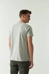 Remera gris de manga corta con cuello redondo y estampado con el logo de la marca y diseño de hojas.