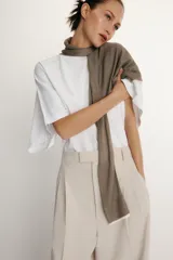 Camiseta blanca de manga corta con corte oversize y cuello redondo. El diseño presenta mangas amplias tipo capa que caen desde el hombro.