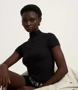 Blusa básica de ribana color negro, con cuello alto y mangas cortas.