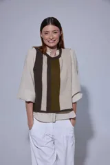 Chaleco de tejido de punto con diseño de bloques de color en tonos tierra, incluyendo marrón, verde oliva y beige. Presenta un panel central con textura tejida y cuello redondo.