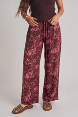 Pantalón de corte recto y tiro medio, confeccionado en viscosa fluida con diseño estampado tipo paisley y floral en tonos bordó y rosado. Cuenta con cintura elástica y cordón ajustable.