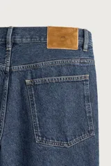 Pantalón jeans de corte regular fit, con pierna recta desde la cadera hasta el tobillo y tiro medio. Confeccionado en denim de algodón rígido con efecto lavado, cuenta con diseño de cinco bolsillos y cierre frontal con botones.