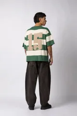 Remera de tejido de punto con diseño de rayas horizontales anchas en color bordó y crema, de corte oversize y cuello redondo.