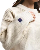 Sweater unisex color crema de lana merino, con cuello redondo y corte holgado.