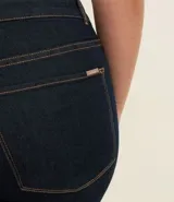Pantalón de jeans azul oscuro, corte skinny, tiro alto, con bolsillos delanteros y traseros.