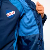 Parka acolchada de corte largo con capucha, color azul marino. Presenta el logo de Umbro en el pecho derecho y el escudo del Club Nacional de Football en el pecho izquierdo. Cuenta con cierre frontal y botones a presión.