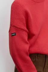 Sweater de punto en color beige, con cuello redondo acanalado, mangas largas con puños ajustados y diseño holgado.