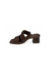 Sandalias de taco medio ancho, color negro, con dos tiras cruzadas en el empeine, punta cuadrada y una hebilla metálica decorativa.