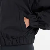 Campera bomber New Balance de corte holgado y diseño minimalista. Presenta cuello camisero, cierre frontal completo, mangas raglán con puños elásticos y cintura elástica. Incluye bolsillos laterales y el logo de la marca bordado en el pecho.