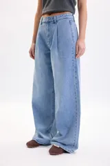 Pantalón wide leg de denim azul medio, de tiro medio con pinzas en la parte delantera y corte ancho en las piernas.