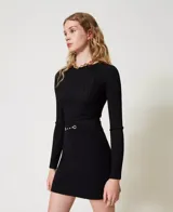 Minifalda negra acampanada de punto con detalle de hebilla plateada en la cintura.