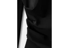 Camiseta negra de diseño asimétrico con cuello alto, una manga larga y el otro hombro descubierto.