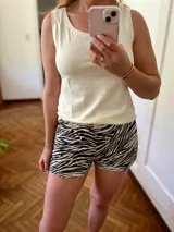 Conjunto de pijama compuesto por musculosa color crema y short con estampado animal print de cebra en blanco y negro.