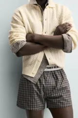 Cárdigan de ajuste relajado, tejido en hilado con lana, color crema. Presenta cuello solapa, manga larga y textura de punto trenzado en todo el cuerpo. Cierre frontal con botones.